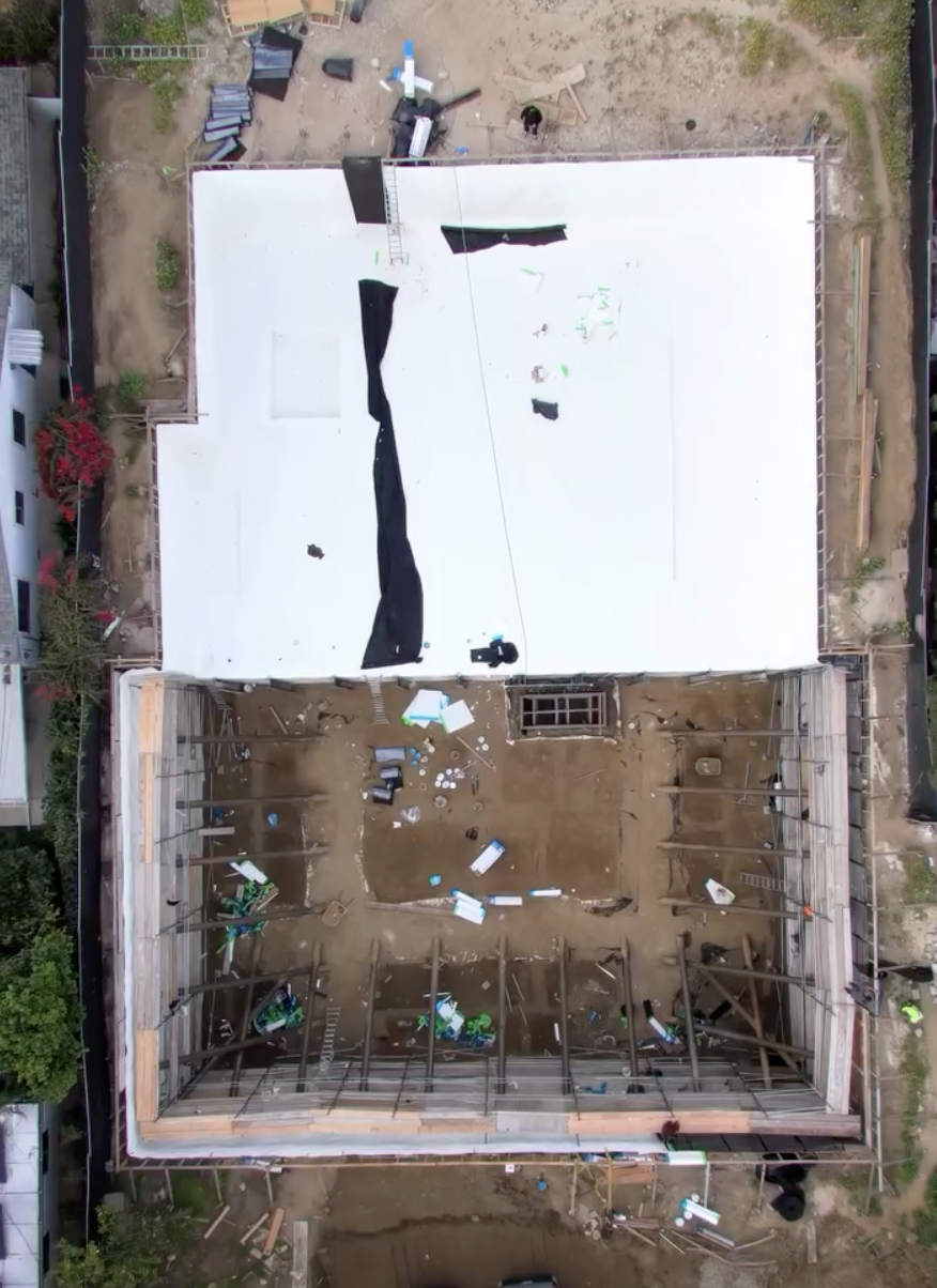 Top-down aerial view of below-grade elevator pit concrete foundation under construction