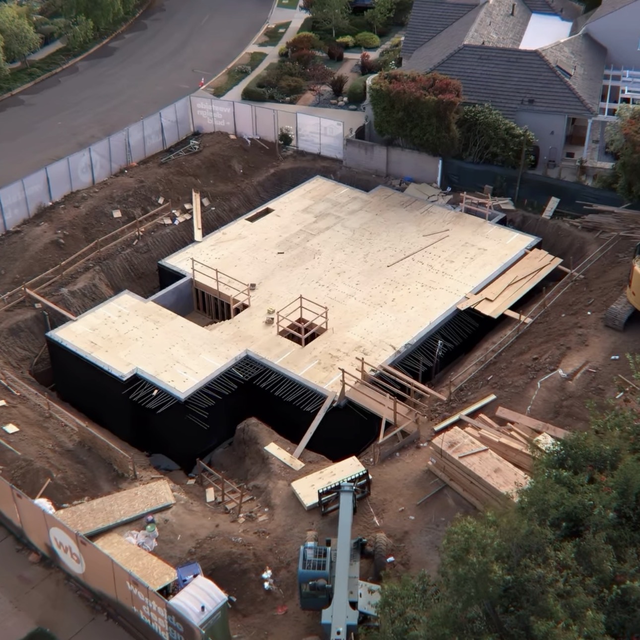 Aerial view of large residential foundation construction site with wood and concrete framing