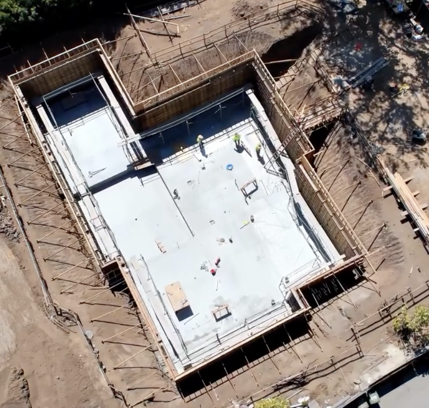 Overhead drone perspective of white under-slab waterproofed basement foundation pit