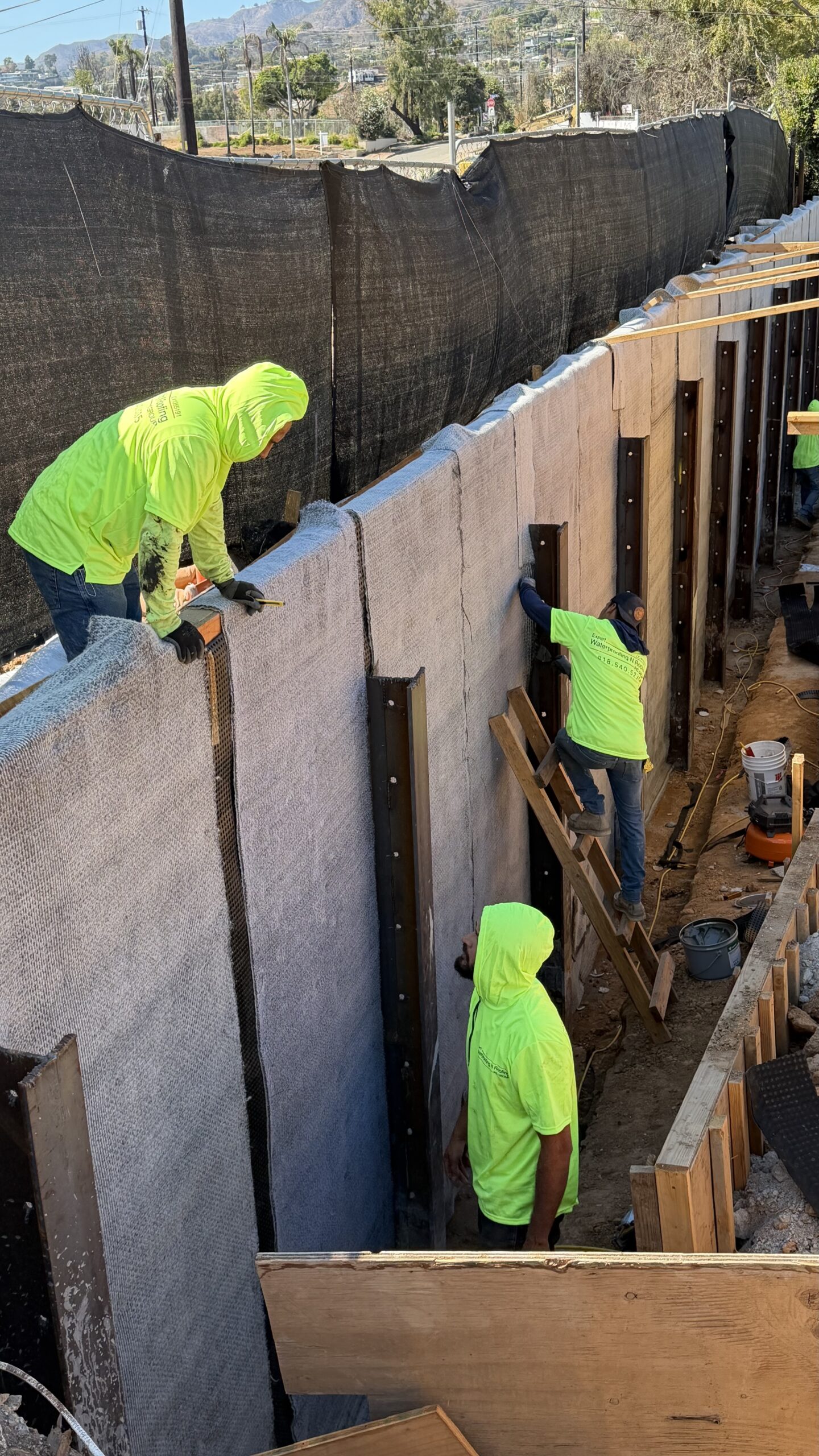 Close-up view of workers detailing vertical joints between concrete wall panels and shoring beams