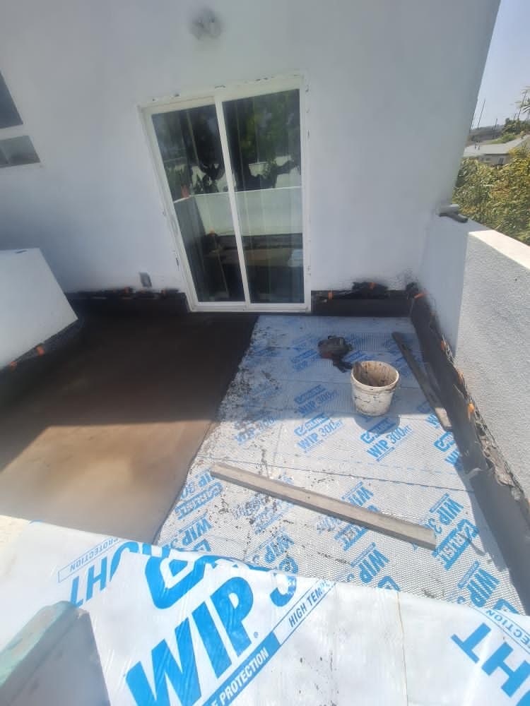 WIP self-adhering waterproofing sheet membrane laid near glass patio door frame